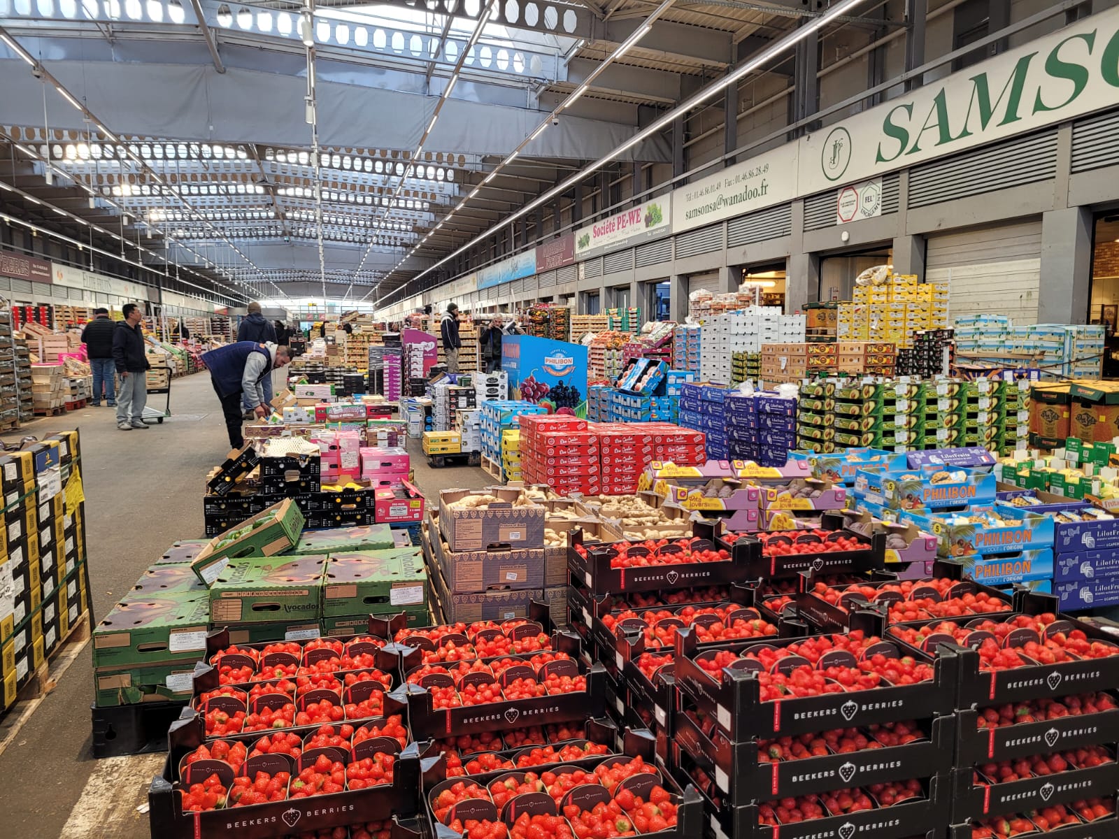 entrepôt où sont superposées des cagettes de fruits et légumes